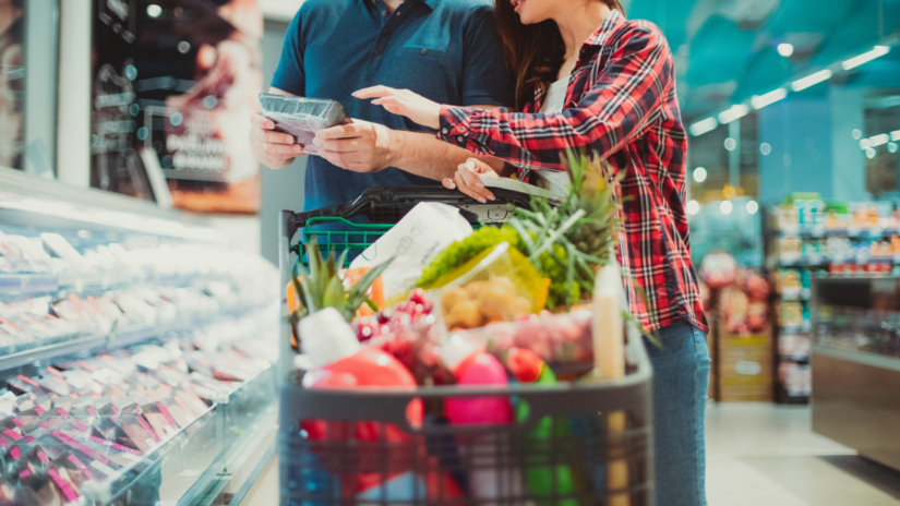 Two people grocery shopping looking at a food label.