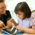 Teacher with two young students using a tablet