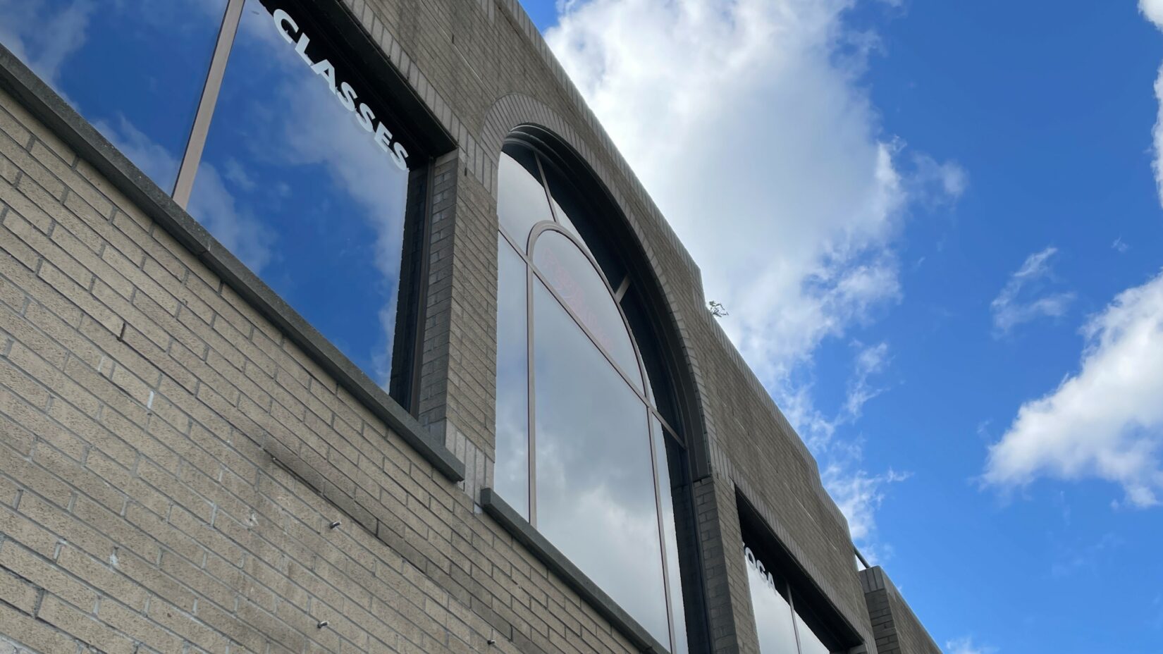 Blue sky with clouds - image perfectly reflected in a shop window