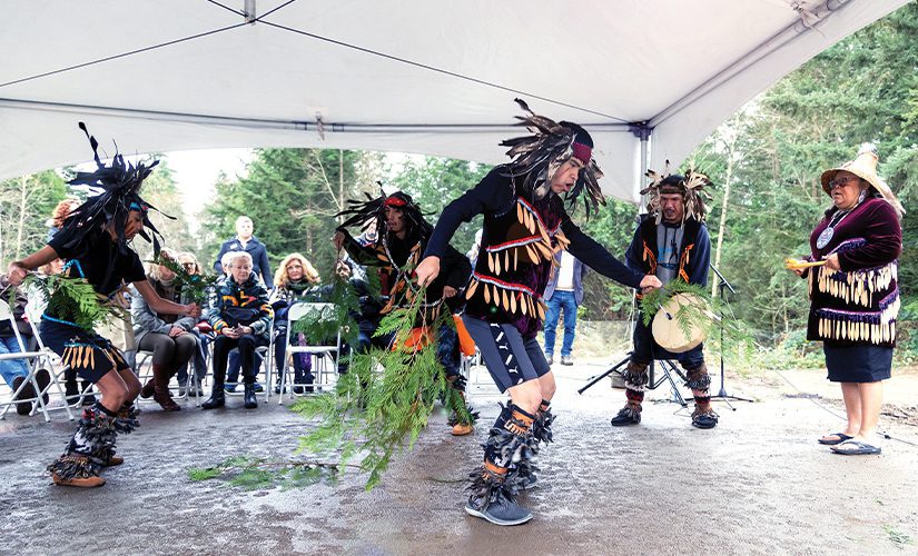 Ceremonial dancers and drummers perform in front of onlookers at the Ground Blessing Ceremony under a white tent, where the Vancouver Island Animal Behaviour Centre will be built.