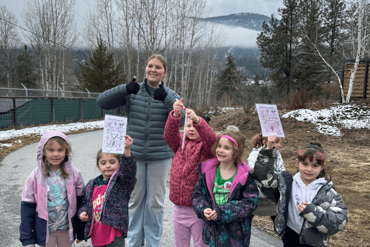 Emily stands surrounded by happy children from our Humane Education program.