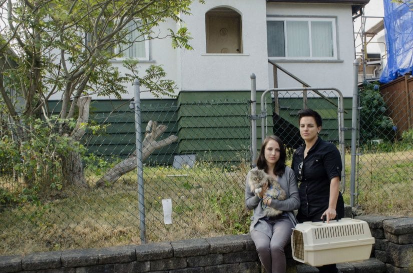 Cat and two women outside of a house