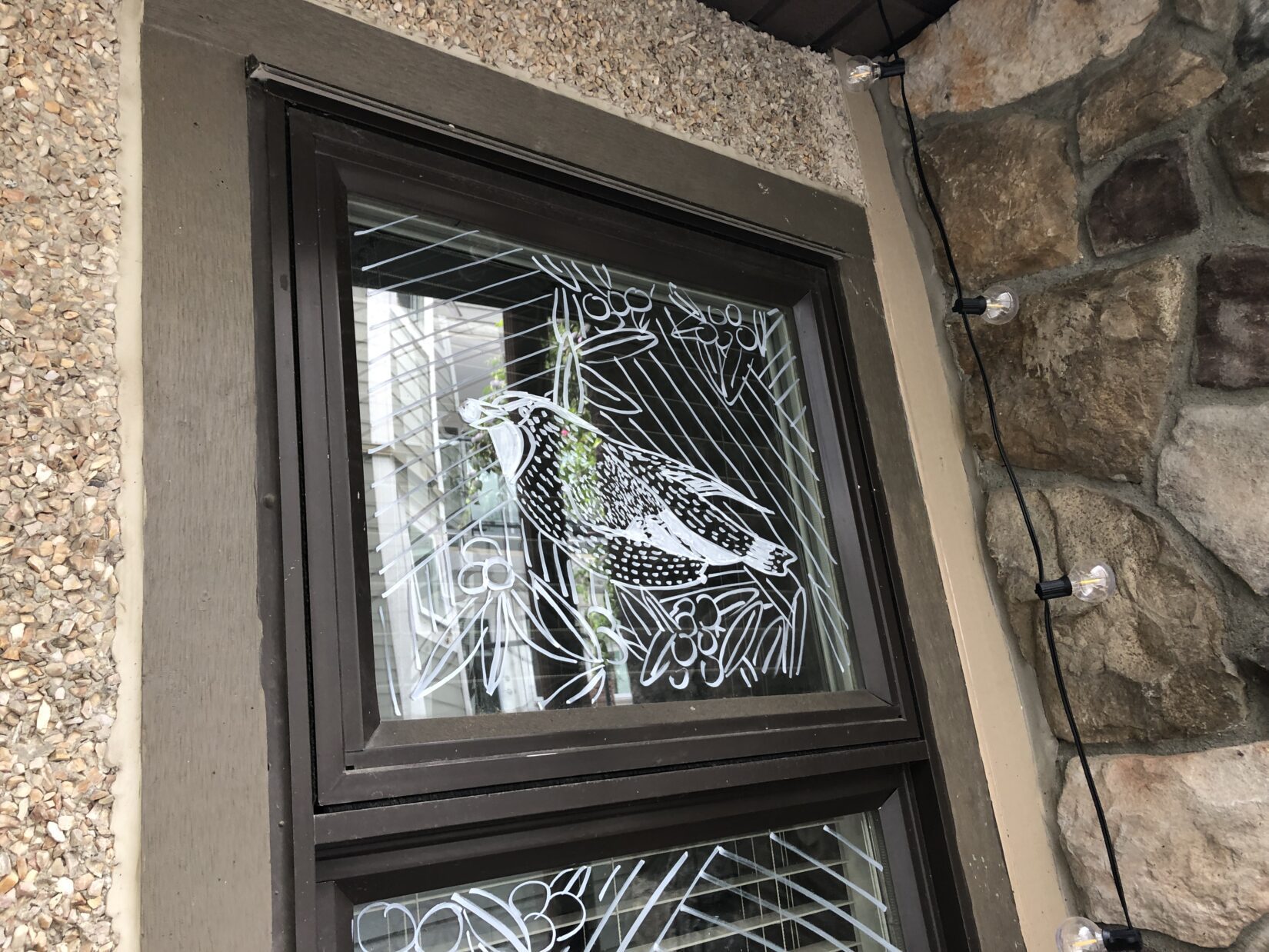 Hand-drawn design on a window to prevent bird strikes