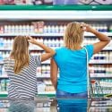Woman and daughter grocery shopping, confused about what to buy.